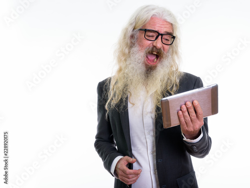 Studio shot of happy senior bearded businessman smiling and laug photo