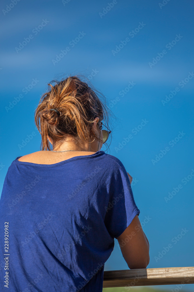 Woman dressed in blue, enjoying the river landscape Woman dressed in blue, enjoying the river landscape