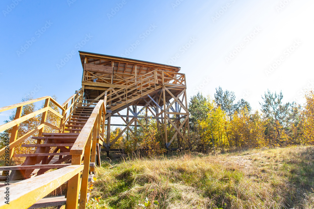 small wooden open house on top of a hill in the sun