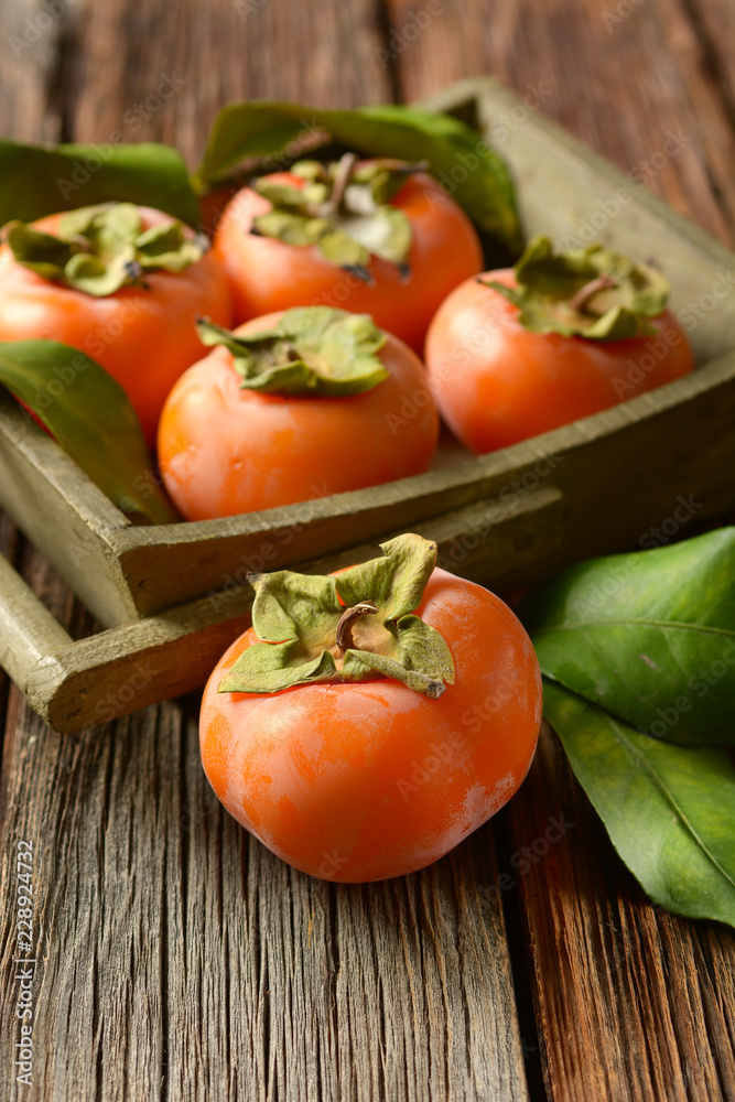 pile of ripe persimmons on wooden table