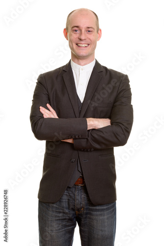 Happy bald Caucasian businessman smiling with arms crossed