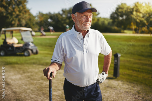 Senior man looking down the fairway of a golf course