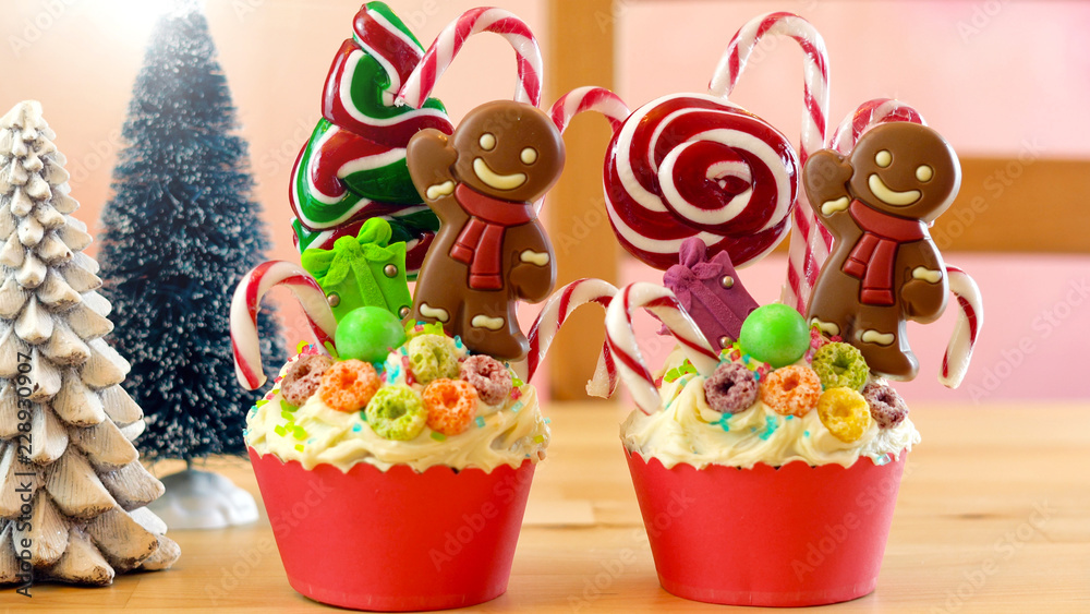 On-trend candyland festive Christmas cupcakes in colorful party table setting.