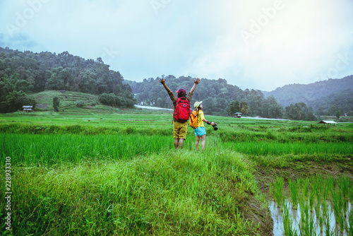 Lover asian men asian women travel nature Travel relax Walking a photo on the rice field in rainy season in Chiang Mai, Thailand