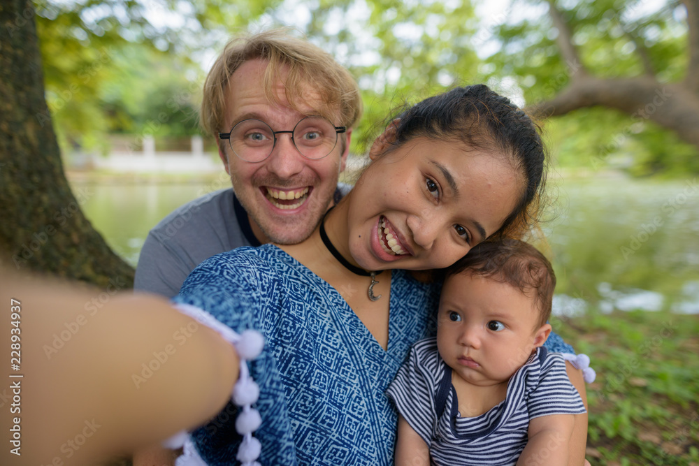 Multi-ethnic young family bonding together at the park Multi-ethnic young family bonding together at the park
