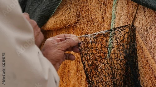 The fisherman repairs the fishing net.
