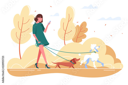 Young woman walks with dog through the woods.