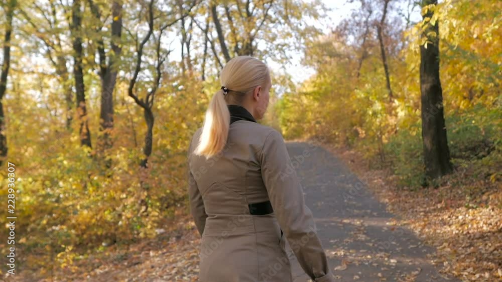 Woman in autumn park running away from persecution Woman in autumn park running away from persecution