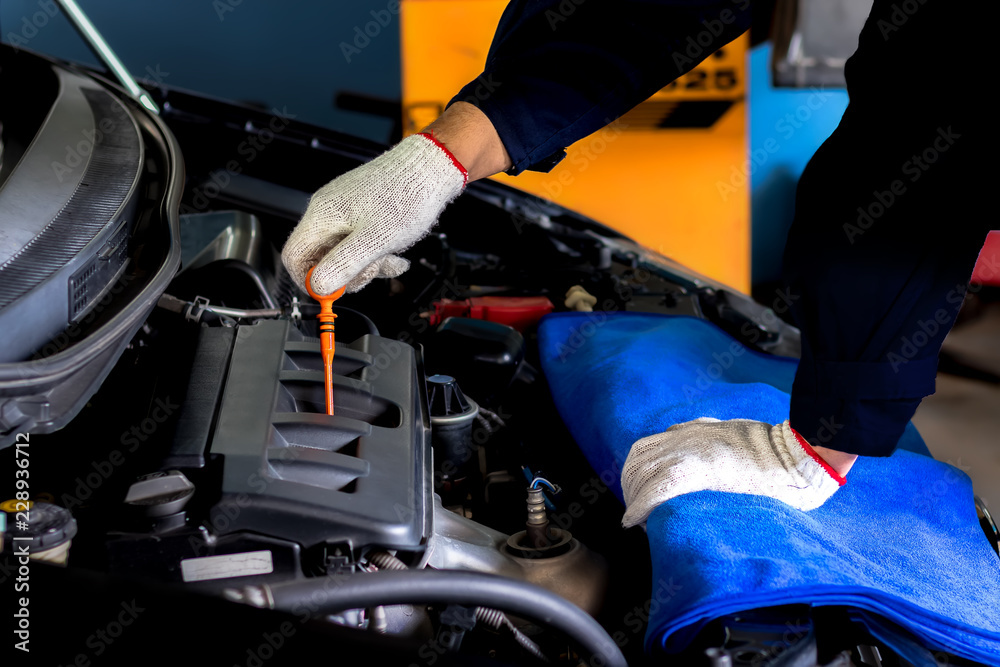 A mechanic Check the oil. Work equipment such as glove.Concept Service by car..