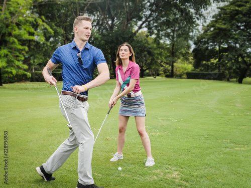 Golfer teaching his girlfriend how to play golf, lifestyle concept.