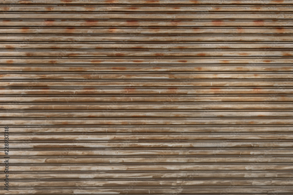A closeup shot of automatic metal roller door used in factory, storage, garage, and industrial warehouse. The corrugated and foldable metal sheet offer space saving and provide urban and rustic feel A closeup shot of automatic metal roller door used in factory, storage, garage, and industrial warehouse. The corrugated and foldable metal sheet offer space saving and provide urban and rustic feel
