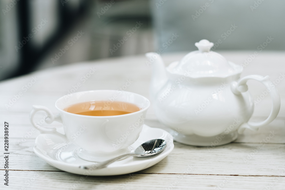 Cup of english tea with white pot and cup on luxury wooden table, copy space Cup of english tea with white pot and cup on luxury wooden table, copy space