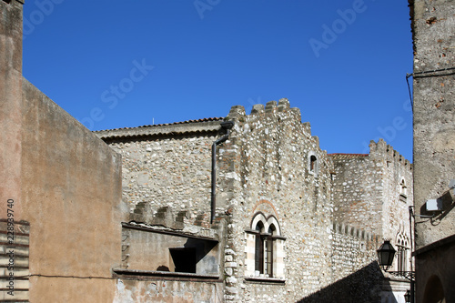 Narrow steets and historic buildings in Taormina, small town on the east coast of the island of Sicily, Italy photo