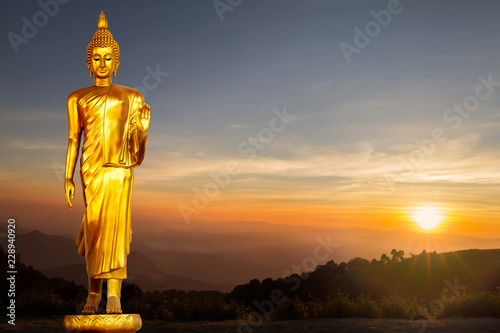 Golden Buddha statue on sunrise background