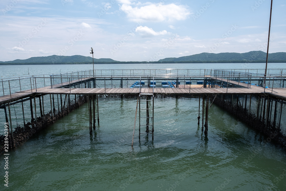 Wooden pedestrian path over sea surface with beautiful view of Ao Khung Kraben bay at Sea Fish Farming Demonstration Unit, Royal Project, Ta Mai District, Chanthaburi. Wooden pedestrian path over sea surface with beautiful view of Ao Khung Kraben bay at Sea Fish Farming Demonstration Unit, Royal Project, Ta Mai District, Chanthaburi.