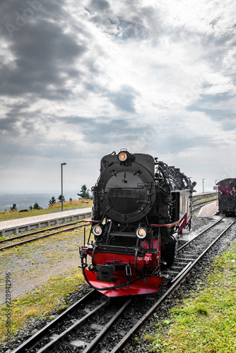 Black locomotive with red color driving on a railtrack