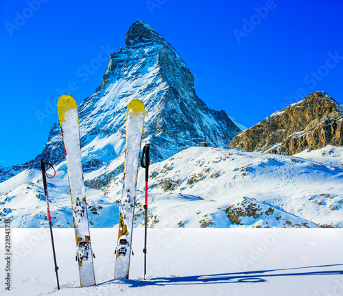 Ski in winter season, mountains and ski touring backcountry equipments on the top of snowy mountains in sunny day with Matterhorn in background, Zermatt in Swiss Alps. © Gorilla