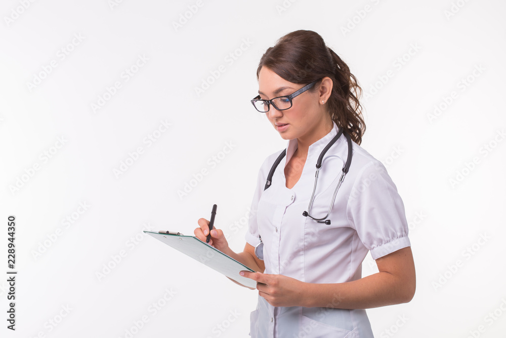 Medicine, health and treatment concept - Happy smiling doctor writing on clipboard, isolated on white background Medicine, health and treatment concept - Happy smiling doctor writing on clipboard, isolated on white background