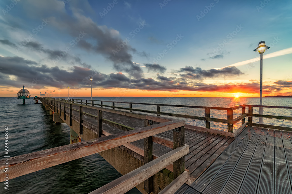 Seebrücke Zinnowitz auf der Ostsee-Insel Usedom mit Tauchglocke bei Sonnenaufgang im Gegenlicht