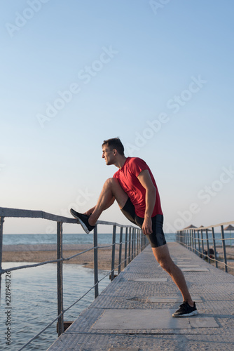 A man stretches out on a bridge