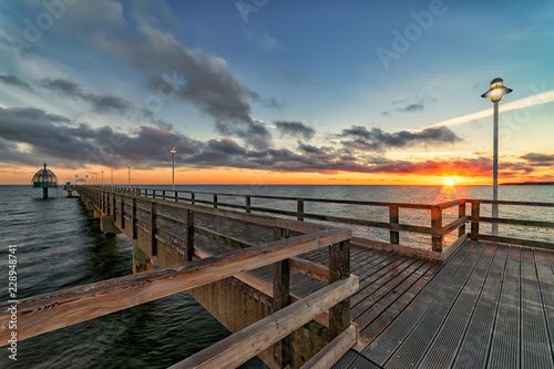 Seebrücke Zinnowitz auf der Ostsee-Insel Usedom mit Tauchglocke bei Sonnenaufgang im Gegenlicht