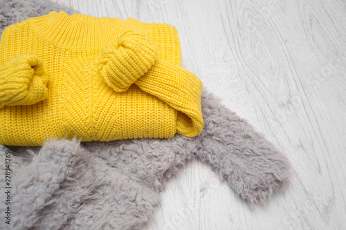 Folded yellow sweater on a wooden background