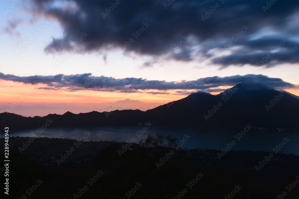 Sunrise view from Gunung Batur volcano in Bali with visible Mount Agung volcano