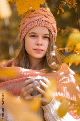 Girl drinking cocoa in autumn park