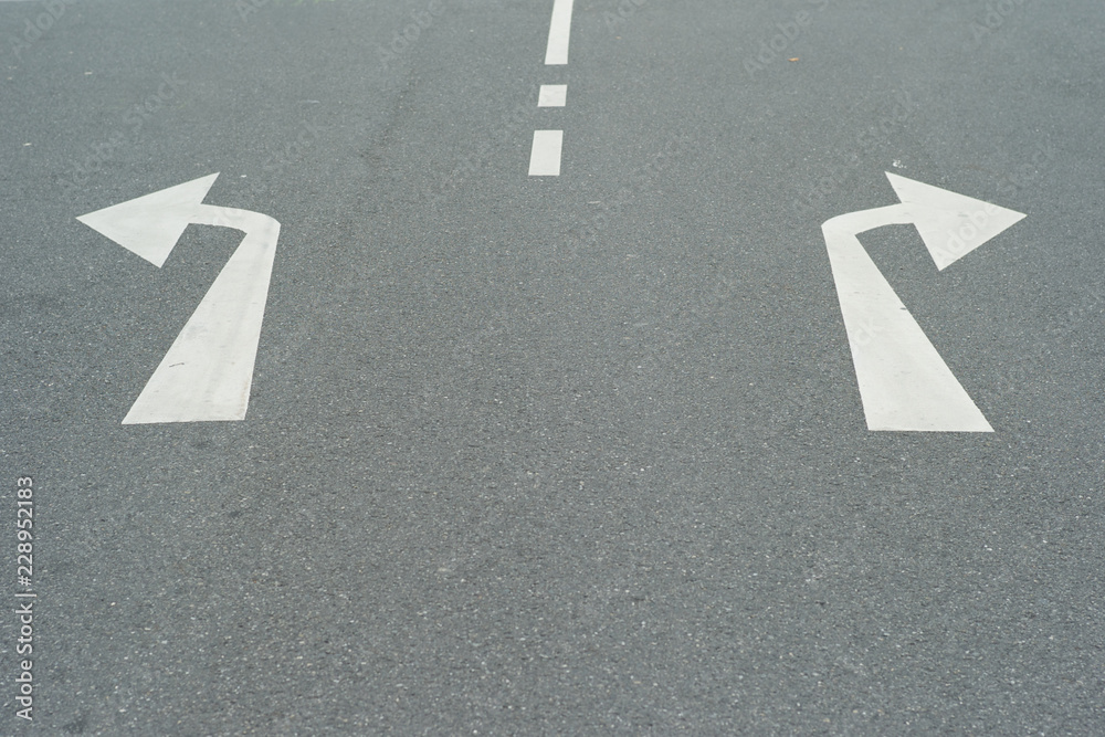 Arrows to the Right and Left on an Asphalt Road - A Concept for Decisions - Turning Left or Right