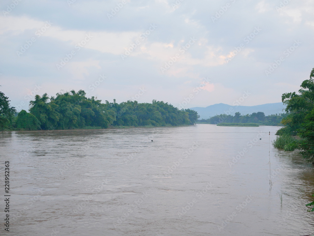 Brown muddy river in a rural area after a heavy rain