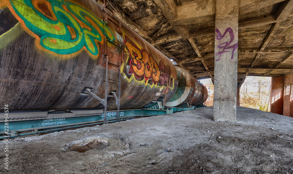 Old rusty fuel tank train inside old abandoned station with graffity on it. HDR panoramic image