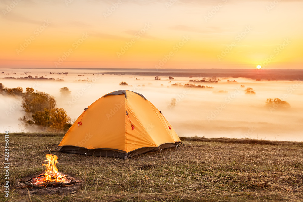 campfire and tent at sunrise