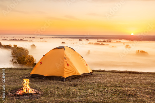 campfire and tent at sunrise