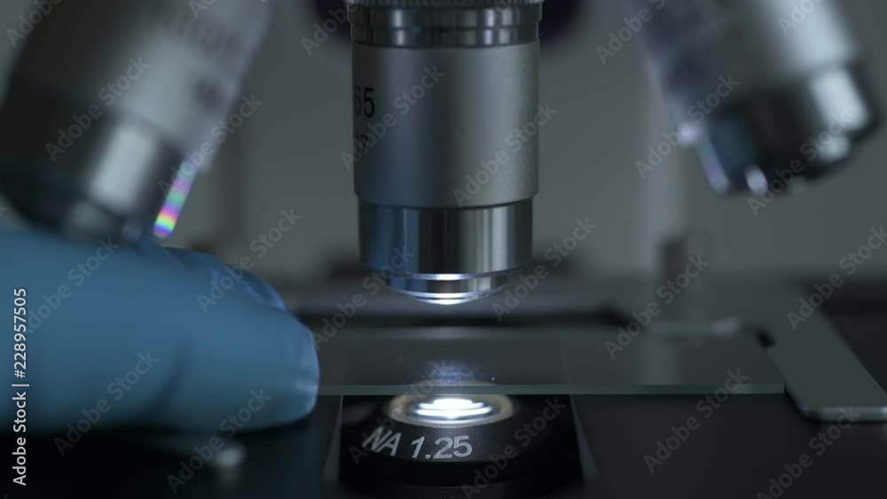 Close-up shot of sample slide and microscope with metal lens at laboratory. Close-up shot of sample slide and microscope with metal lens at laboratory.