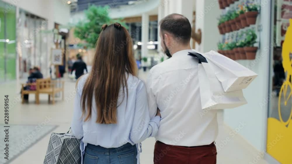 Couple with bags walking through the mall Couple with bags walking through the mall