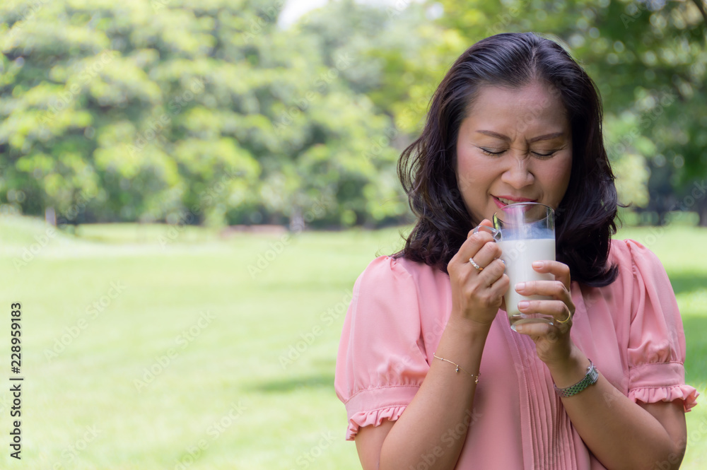 Asian retirement women are drinking milk for good health with blurred soft green nature background To health concept. Asian retirement women are drinking milk for good health with blurred soft green nature background To health concept.