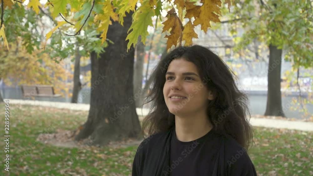 Caucasian teenager In City Smile Happy Face. Emotional Woman Portret.girl walking In The Park in autumn. slow motion Caucasian teenager In City Smile Happy Face. Emotional Woman Portret.girl walking In The Park in autumn. slow motion