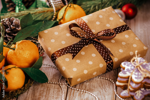 Christmas composition - present box and gingerbread cookie, anise and cinnamon on wooden table