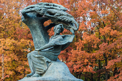 Monument to Fryderyk Chopin, famous Polish composer, in Royal Baths Park, the best-known Polish sculpture in the world by Waclaw Szymanowski on the red trees background.