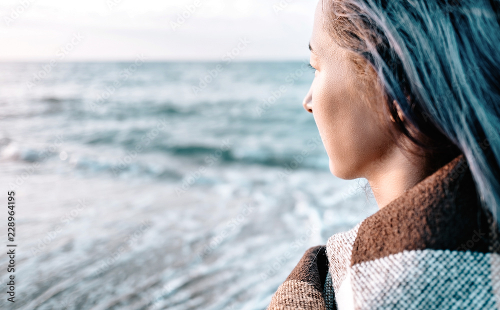 Woman with blue hair looking at the sea. Woman with blue hair looking at the sea.