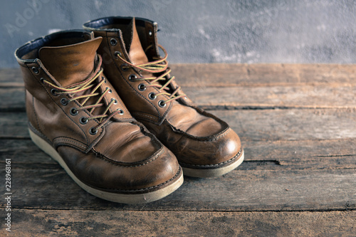 brown vintage leather boots on wooden background