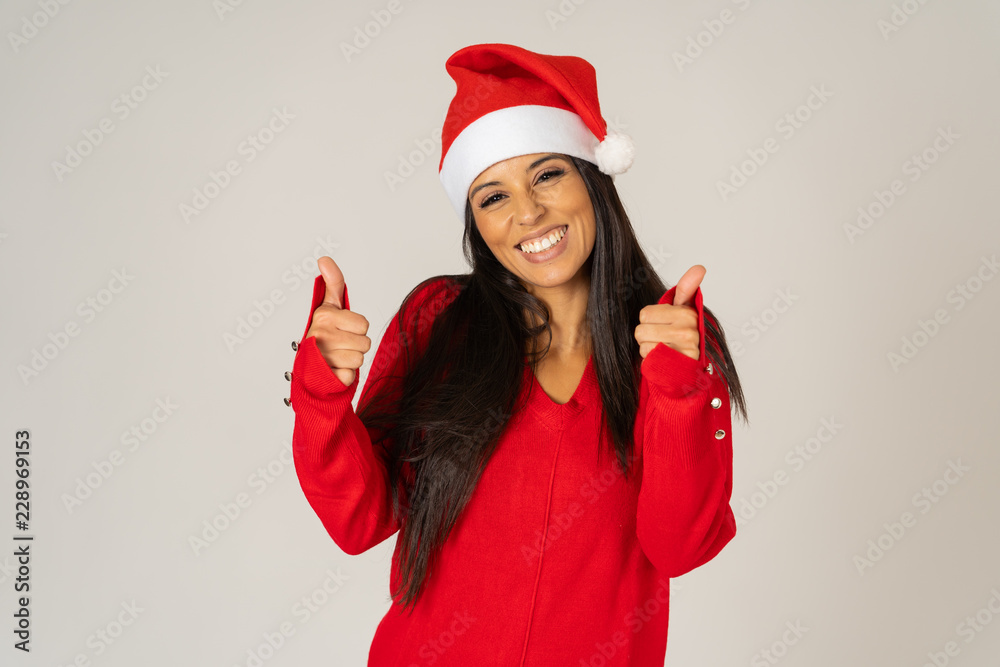 Attractive sexy girl posing in red dress and santa hat isolated on grey background Attractive sexy girl posing in red dress and santa hat isolated on grey background