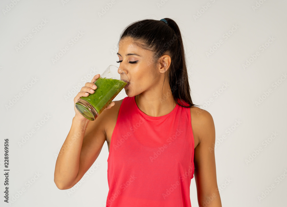 Happy beautiful fit sport woman smiling and drinking healthy fresh vegetable smoothie Happy beautiful fit sport woman smiling and drinking healthy fresh vegetable smoothie