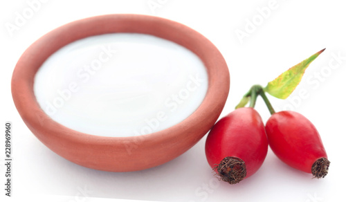 Rose hips with fresh milk in a pottery