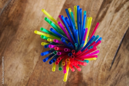 Colored plastic straws gathered in a glass, top view.