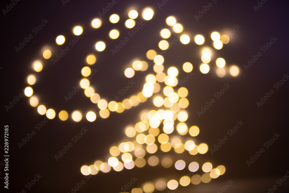 Blurred Christmas lights on black background - crescent moon, star and Christmas’s tree garland bright abstract image - xmax defocused bokeh gold background Blurred Christmas lights on black background - crescent moon, star and Christmas’s tree garland bright abstract image - xmax defocused bokeh gold background