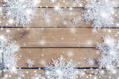 Wooden brown christmas background and snow white with snowflakes, copy space.