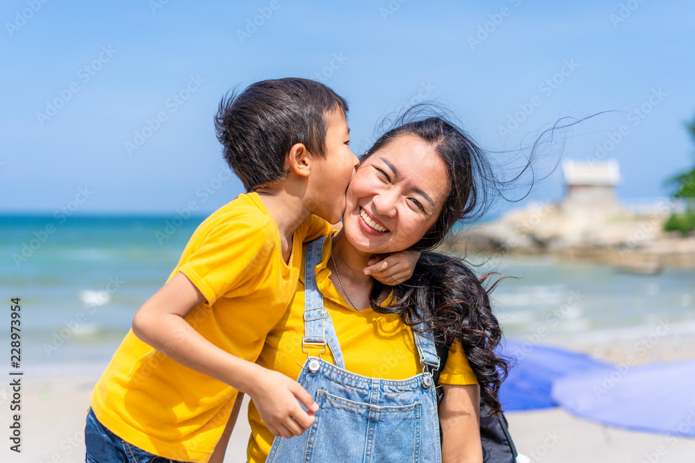 Asian mother and son enjoy relaxing on the beach