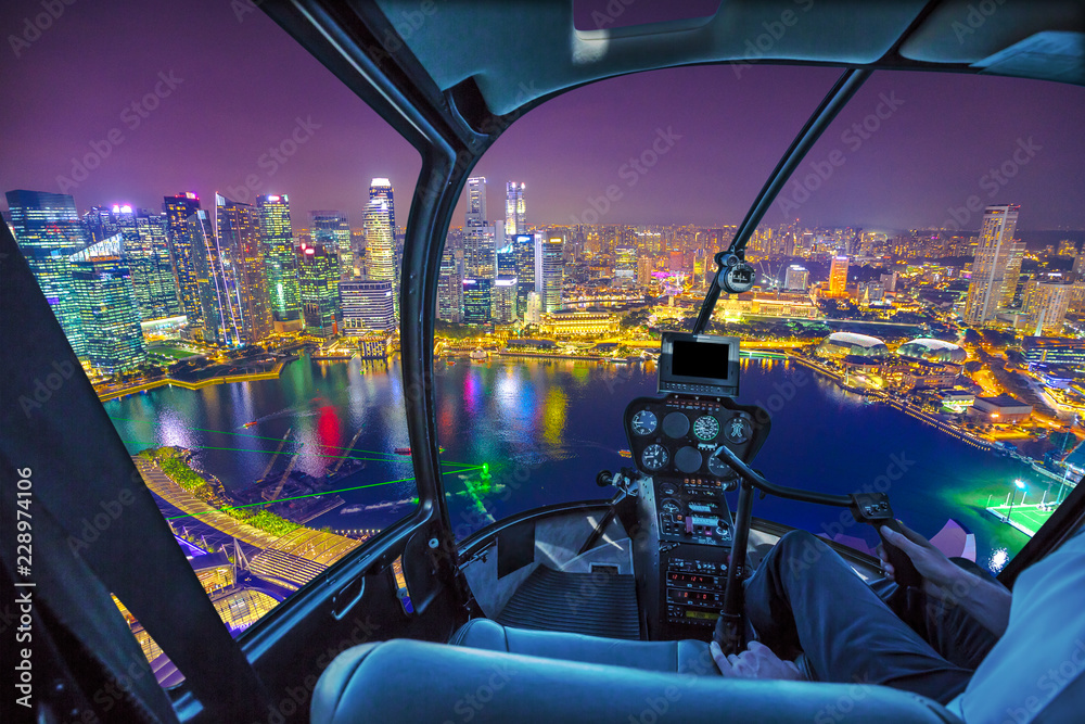 Fototapeta premium Malowniczy lot helikopterem nad panoramą Singapuru o świcie. Nocna scena miejska antena. wnętrze kokpitu z wieżowcami dzielnicy finansowej w nocy na porcie w Singapurze.