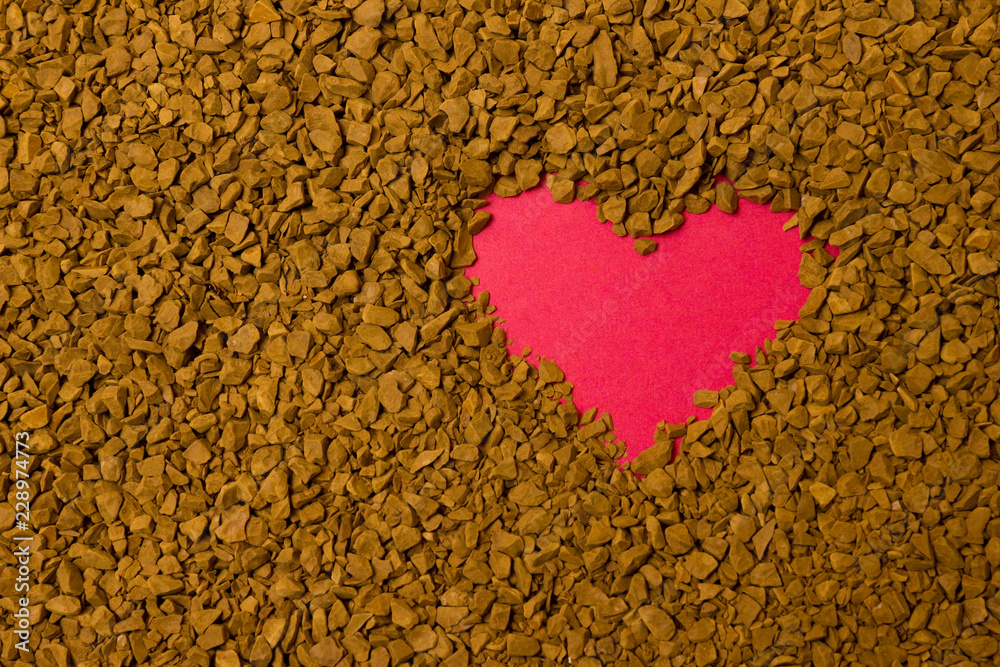 Dry instant coffee granules in the shape of a heart - brown texture Dry instant coffee granules in the shape of a heart - brown texture